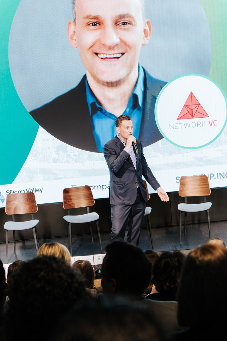 Andrii Moroz presenting on stage under the Network VC logo